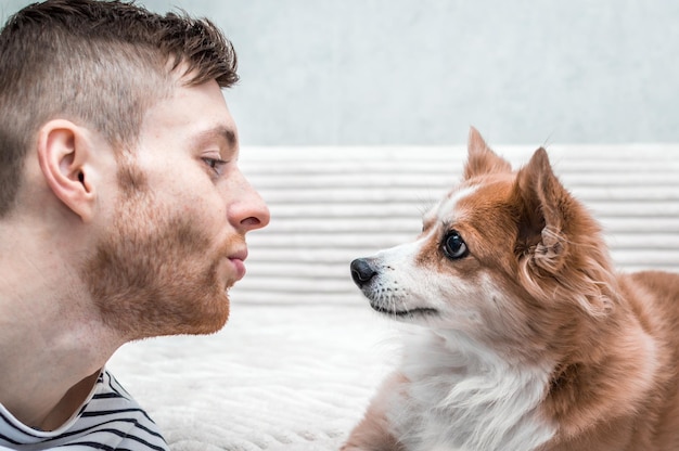 Młody mężczyzna i pies patrzą na siebie. Portret zbliżenie