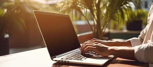 Młody mężczyzna korzystający z laptopa w słonecznym biurze, pracujący jako niezależny bloger lub dziennikarz Miejsce na tekst