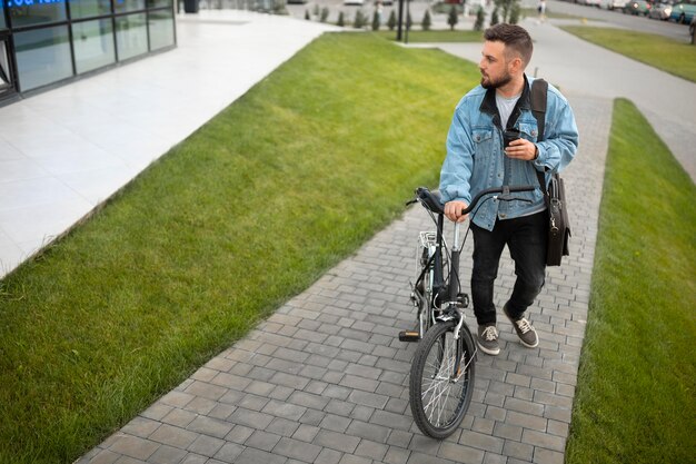 Młody mężczyzna korzystający ze składanego roweru w mieście