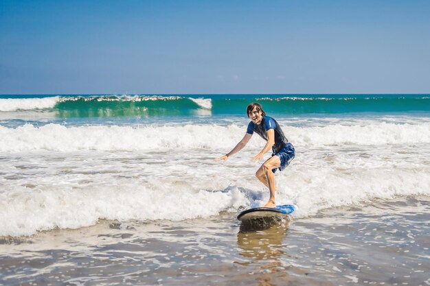 Młody mężczyzna, początkujący Surfer uczy się surfować na morskiej pianie na wyspie Bali