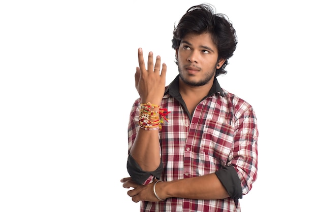 Młody mężczyzna pokazujący rakhi na dłoni z okazji festiwalu Raksha Bandhan.