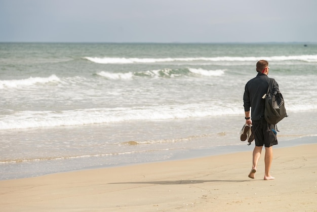 Młody mężczyzna przechodzący na China Beach, Danang w Wietnamie. Bez twarzy