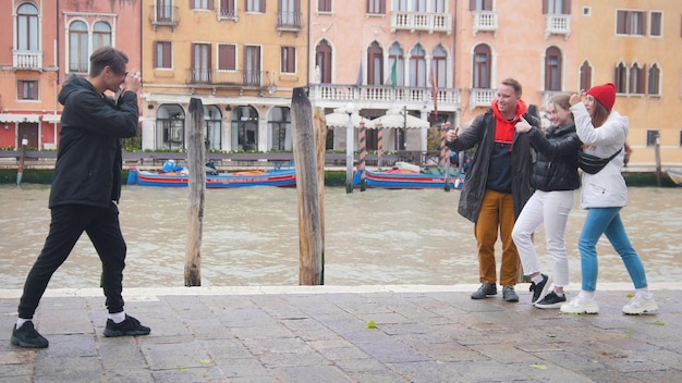 Młody mężczyzna robi zdjęcie swoim przyjaciołom na nabrzeżu w Wenecji