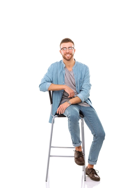 Młody mężczyzna siedzi na krześle izolowanym na białym tle Startupper Młody przedsiębiorca