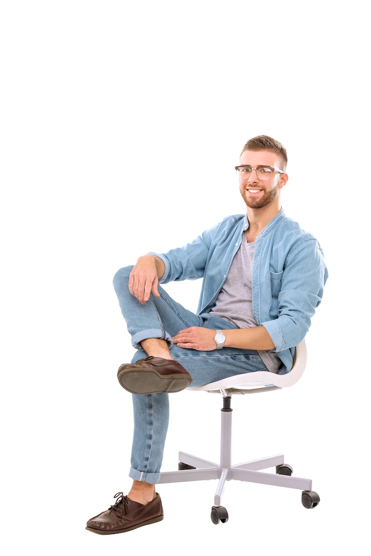 Młody mężczyzna siedzi na krześle izolowanym na białym tle Startupper Młody przedsiębiorca