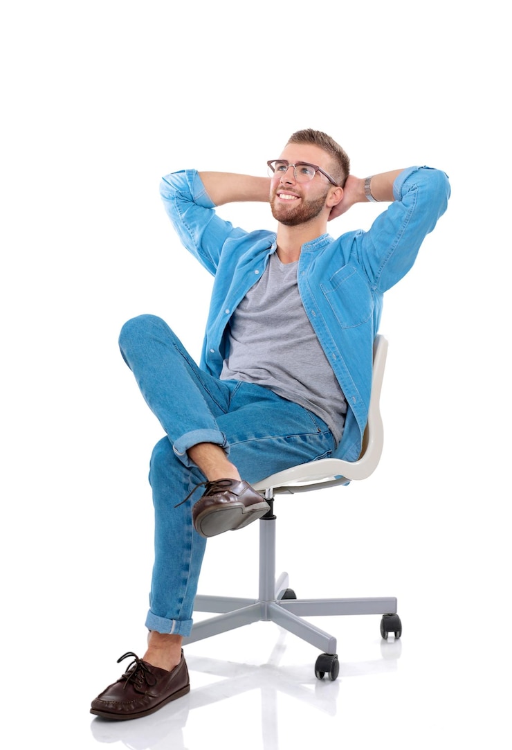 Młody mężczyzna siedzi na krześle izolowanym na białym tle Startupper Młody przedsiębiorca