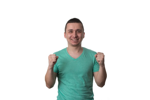 Młody mężczyzna świętuje zwycięstwo na białym tle