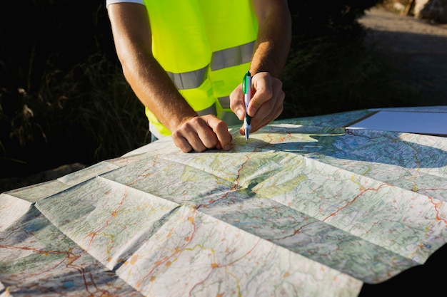Zdjęcie młody mężczyzna szuka lokalizacji na papierowej mapie