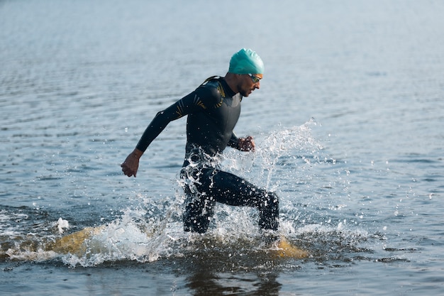 Młody mężczyzna triathlon sportowiec biorący udział w zawodach sportowych na świeżym powietrzu