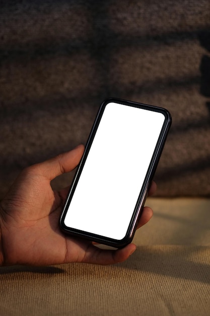 Młody mężczyzna trzyma makieta inteligentny telefon z białym pustym ekranem Zamknij widok