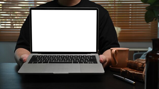 Młody mężczyzna trzyma makiety laptopa z pustym ekranem