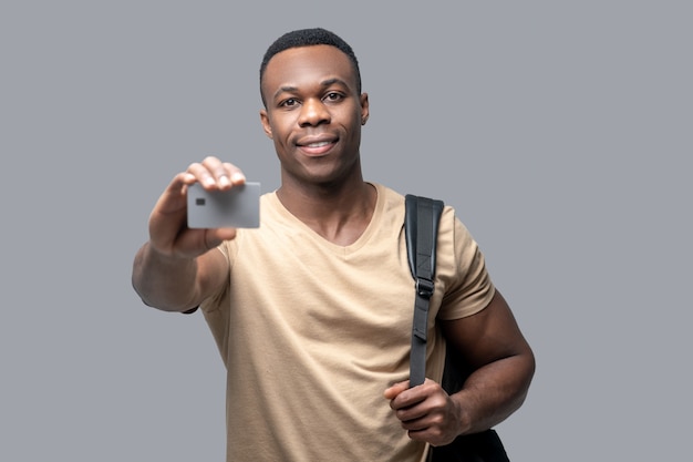 Młody mężczyzna trzymający w rękach kartę kredytową