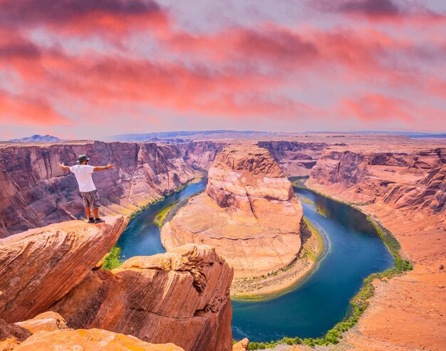 Młody Mężczyzna W Białej Koszuli I Zielonym Kapeluszu W Horseshoe Bend W Arizonie. Stany Zjednoczone