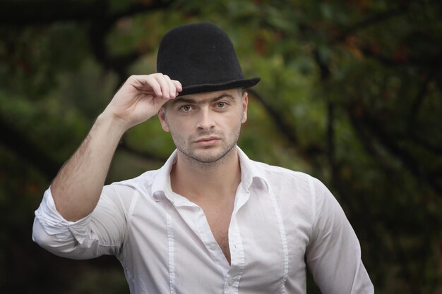 Zdjęcie młody mężczyzna w kapeluszu stoi na zewnątrz
