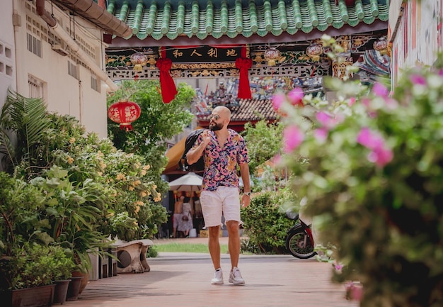 Młody mężczyzna z plecakiem na tle azjatyckiej świątyni