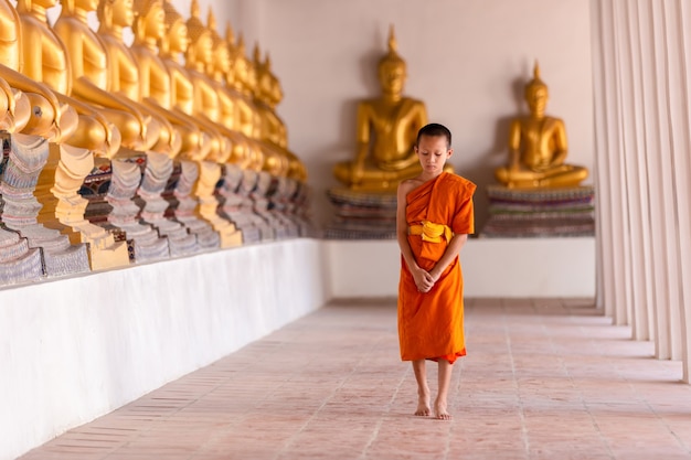 Młody mnich-nowicjusz idący do medytacji w świątyni Wat Phutthai Sawan, Ayutthaya, Tajlandia