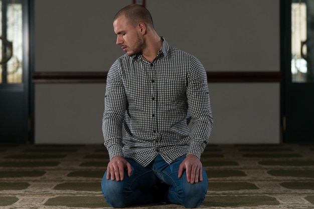 Młody muzułmanin odmawiający tradycyjną modlitwę do Boga Allaha