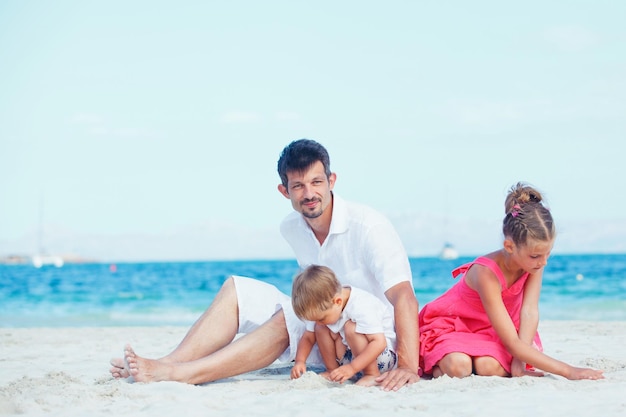 Zdjęcie młody ojciec i jego dziecko bawiące się na plaży