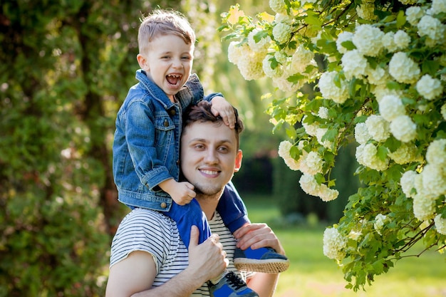 Młody Ojciec I Jego Uśmiechnięty Syn W Parku, Przytulanie I Spędzanie Czasu Razem, Obchody Dnia Ojca.