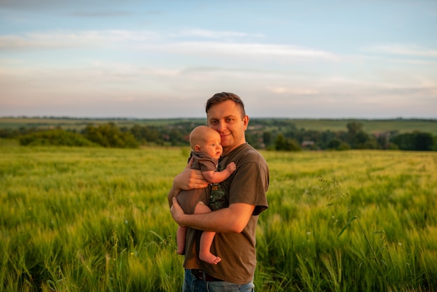 Młody ojciec trzyma syna w ramionach