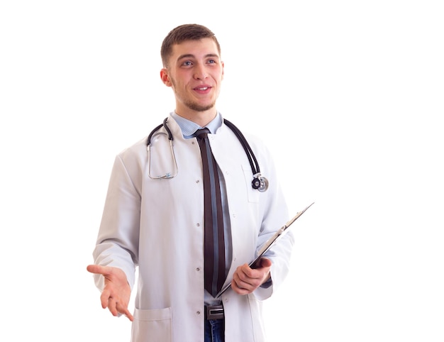 Młody optymistyczny mężczyzna o brązowych włosach w niebieskiej koszuli i sukni lekarskiej ze stetoskopem