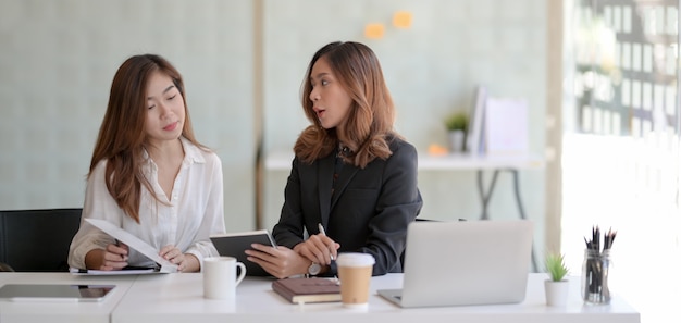 Młody piękny bizneswoman wyjaśnia jej pomysły jej coworker w nowożytnym biurze