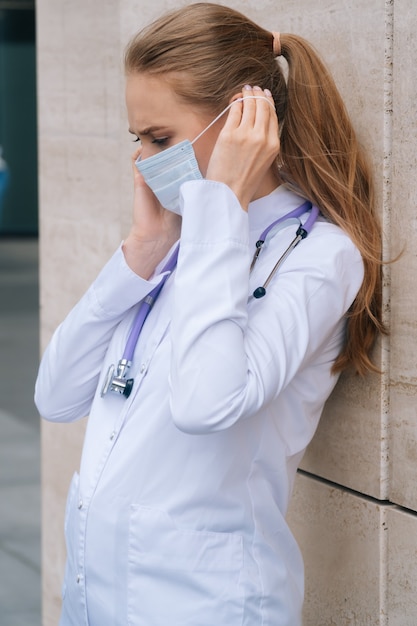 Zdjęcie młody piękny lekarz ze stetoskopem i maską medyczną