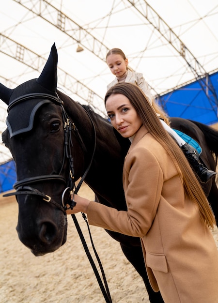 Młody piękny model kobiety z koniem stwarzających Portret damy na ranczo