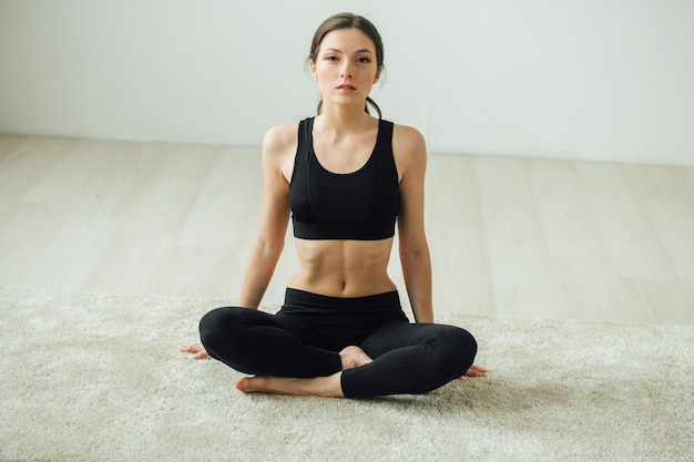 Młody piękny sportowy kobieta domu robi trening sportowy. Strzał studio.