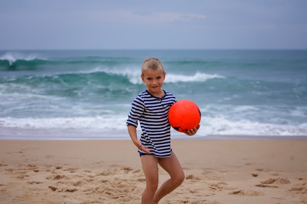 Zdjęcie młody piłkarz gra boso na brzegu oceanu piłka nożna sport pasja aktywny tryb życia