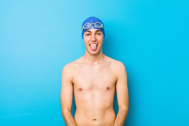 Młody pływak człowiek zabawny i przyjazny wystaje język.