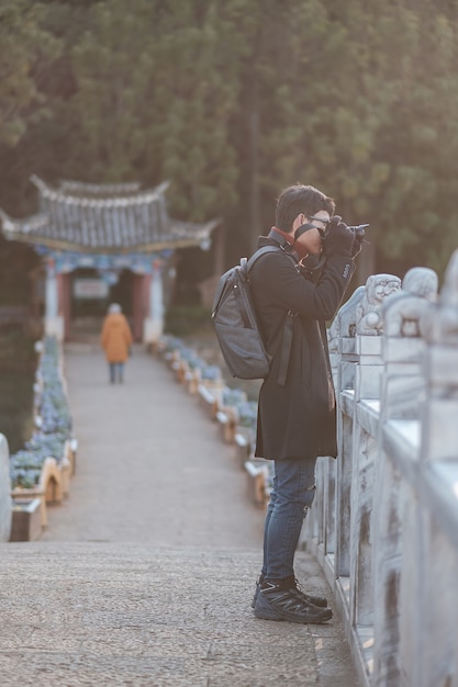 Młody Podróżnik Podróżujący W Basenie Black Dragon Z Jade Dragon Snow Mountain, Punktem Orientacyjnym I Popularnym Miejscem Atrakcji Turystycznych W Pobliżu Starego Miasta W Lijiang. Lijiang, Yunnan, Chiny