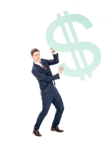 Zdjęcie młody pomyślny biznesmen trzyma dużego dolarowego symbol odizolowywającego na bielu