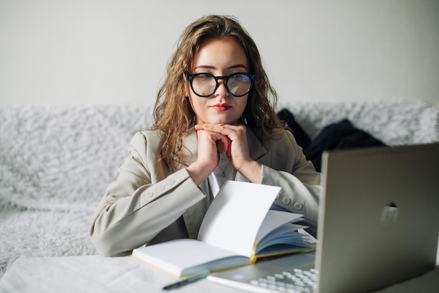 Młody poważny zajęty profesjonalny bizneswoman pracownik lub student w okularach za pomocą laptopa