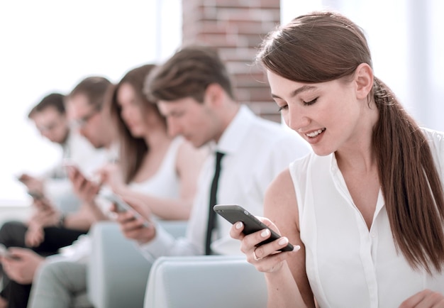 Młody pracownik patrzący na wiadomość tekstową na smartfonie