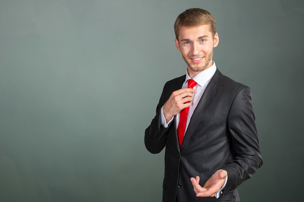 Młody przystojny biznesmen przystosowywa jego krawat