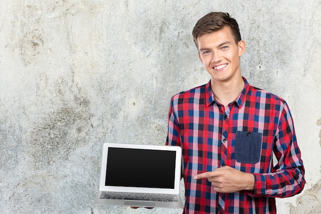 Młody przystojny biznesmena mienia laptop