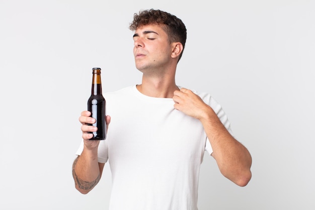 Młody Przystojny Mężczyzna Czuje Się Zestresowany, Niespokojny, Zmęczony I Sfrustrowany, Trzymając Butelkę Piwa