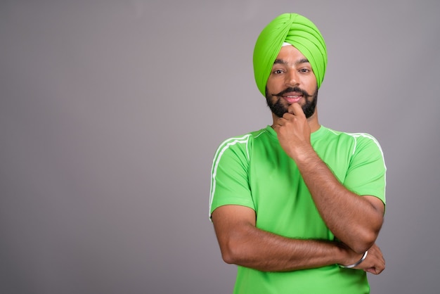 Młody przystojny mężczyzna indyjski Sikhów na sobie turban i zieloną koszulę
