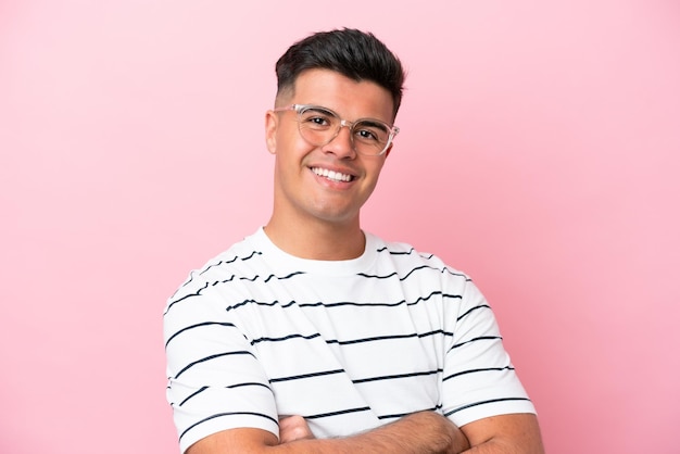 Młody przystojny mężczyzna rasy kaukaskiej odizolowany na różowym tle W okularach z radosnym wyrazem twarzy