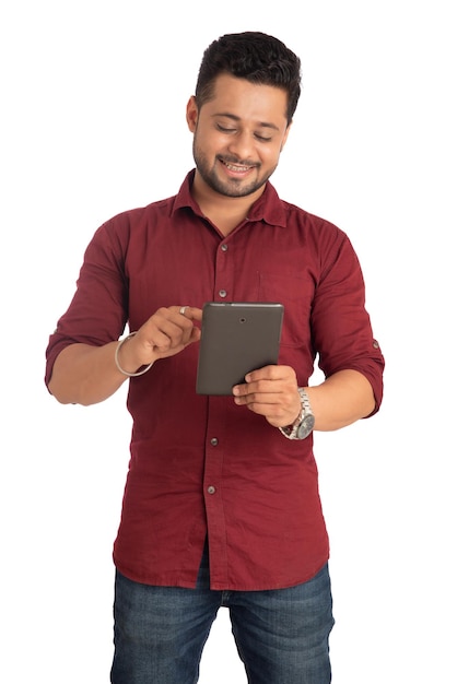 Młody przystojny mężczyzna trzyma i używa smartfona lub telefonu komórkowego lub tabletu na białym tle