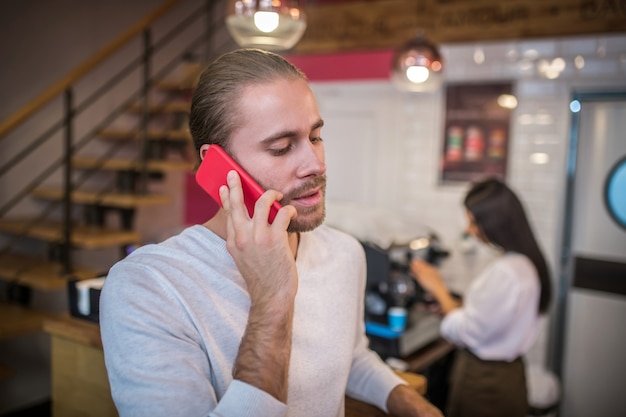 Młody Przystojny Mężczyzna Za Pomocą Telefonu W Kawiarni