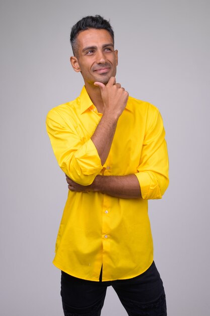 Młody przystojny perski biznesmen z żółtą koszulką
