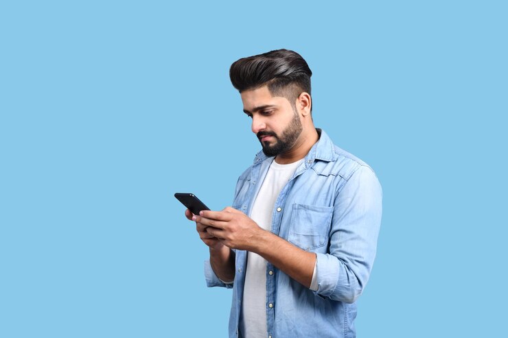 Młody przystojny student dorywczo strój przy użyciu telefonu komórkowego indyjskiego modelu pakistańskiego