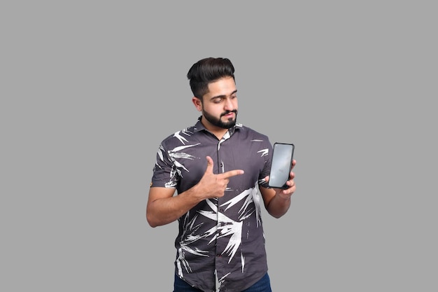 Młody przystojny student dorywczo strój trzymający telefon komórkowy indyjski model pakistański
