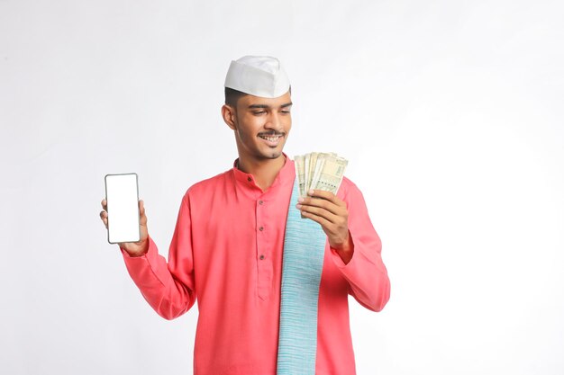 Młody rolnik indyjski Wyświetlono smartphone i pieniądze na białym tle.