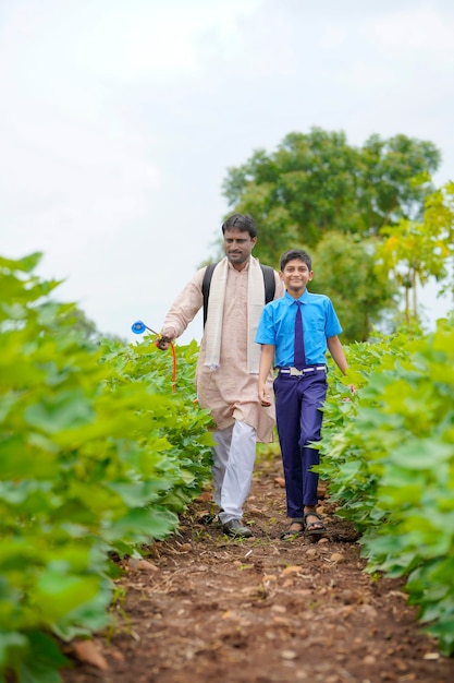 Młody rolnik indyjski z synem w zielonym polu rolnictwa.