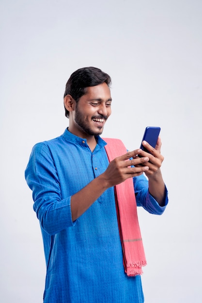 Młody rolnik indyjski za pomocą smartfona na białym tle.