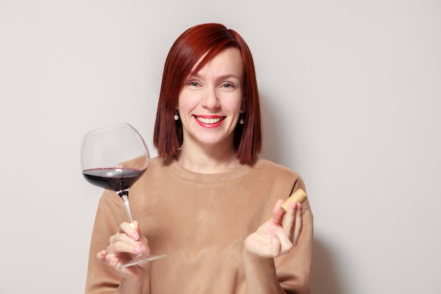 Młody śmieszny redhaired kobiety sommelier z kieliszkiem wina