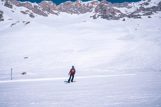 Młody Snowboardzista Zjeżdżający Po Zaśnieżonym Stoku Na Górze W Ośrodku Zimowym